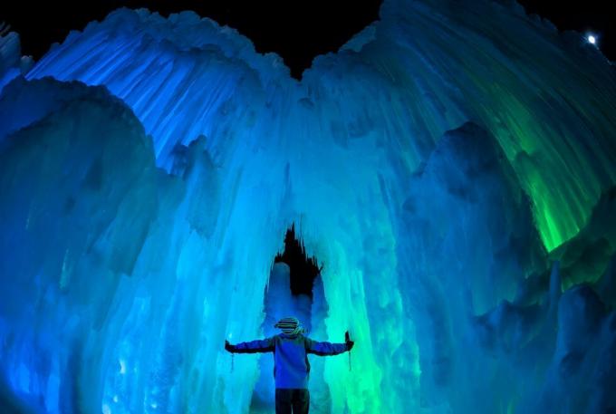 ένα άτομο που στέκεται σε μια μεγάλη σπηλιά πάγου