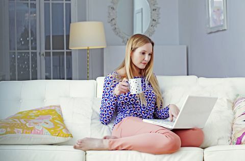 Γυναίκα στο laptop που κάθεται στο σαλόνι της