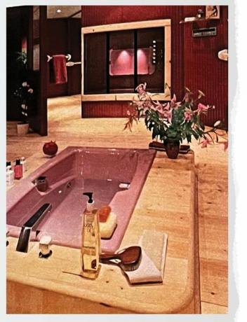 ροζ μπανιέρα σε μπάνιο με ξύλινο δάπεδο