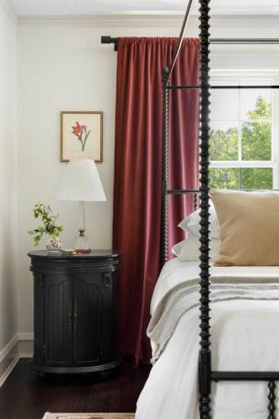 κύριο υπνοδωμάτιο, κόκκινες κουρτίνες, λευκό κρεβάτι με μαύρο πλαίσιο και λευκά κλινοσκεπάσματα, μαύρο τραπεζάκι