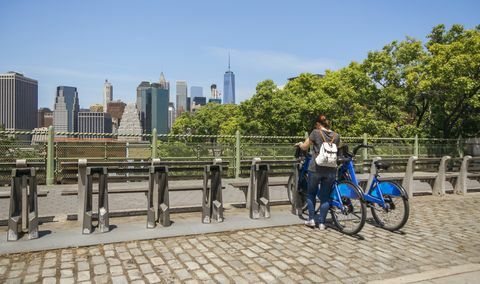 Γυναίκα με ποδήλατο μπροστά στον ορίζοντα του Μανχάταν στη Νέα Υόρκη
