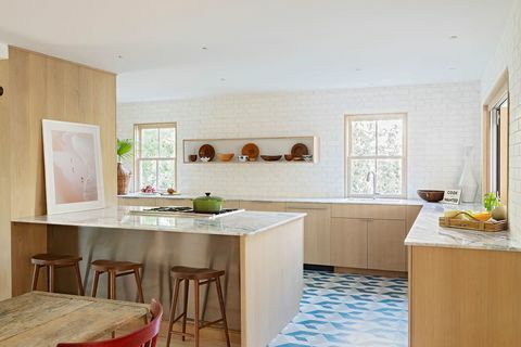 κουζίνα με ξύλινα ντουλάπια, μαρμάρινους πάγκους, μπλε, λευκά και γκρι πλακάκια, ξύλινα σκαμπό μπαρ