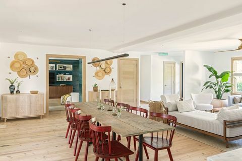 τραπέζι φαγητού, κόκκινες καρέκλες τραπεζαρίας, λευκό σαλόνι, βατράκια στον τοίχο, κρεμαστά καπέλα ως τέχνη, ξύλινο δάπεδο