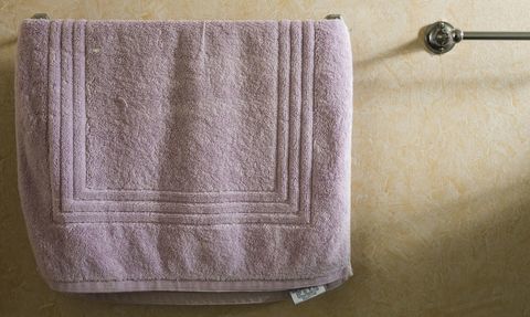 Μια παλιά πετσέτα που κρέμεται σε μια πετσέτα σε ένα μπάνιο