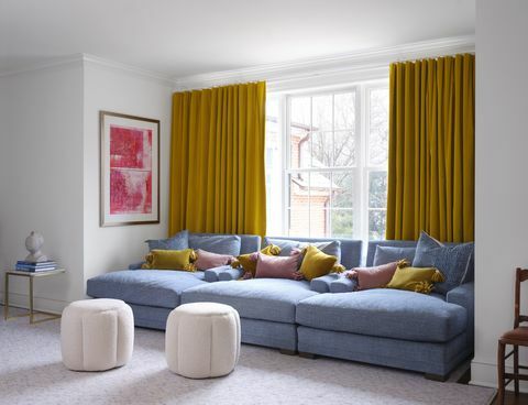 μπλε καναπές, κίτρινες κουρτίνες, ροζ και κίτρινα μαξιλάρια