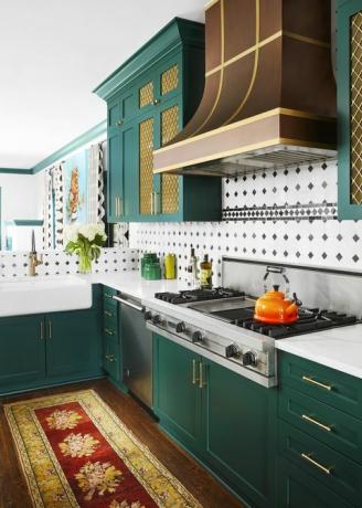 πράσινη κουζίνα, πράσινα ντουλάπια, πορτοκαλί βραστήρα, μαύρο και άσπρο backsplash