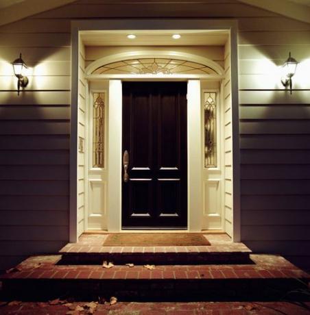 Μπροστινή πόρτα του σπιτιού με φώτα τη νύχτα
